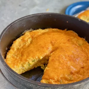 Cheesy cornbread baked in a Dutch oven.