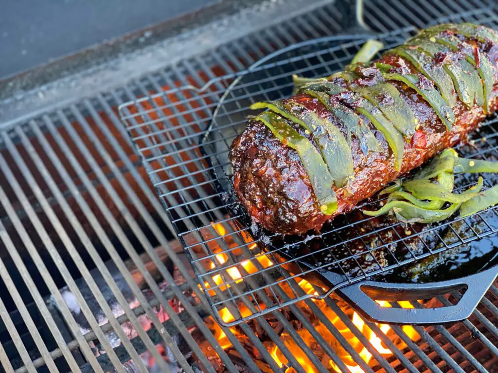 Grilled meat with green peppers on a grill.