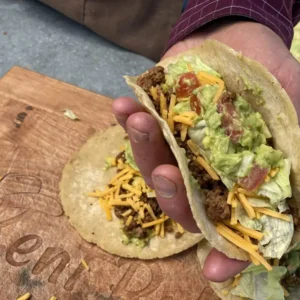 Hand holding a beef and guacamole taco.