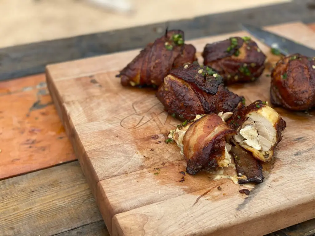 Bacon-wrapped chicken on a cutting board.