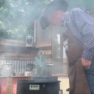 Man in hat checks smoker filled with smoke.