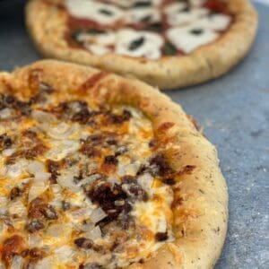 Closeup of a cheesy meat and onion pizza.