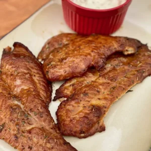 A plate of meat and sauce on the table.