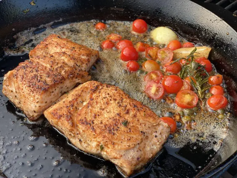 A pan with some meat and tomatoes on it