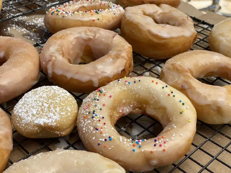 A close up of several doughnuts on a cooling rack