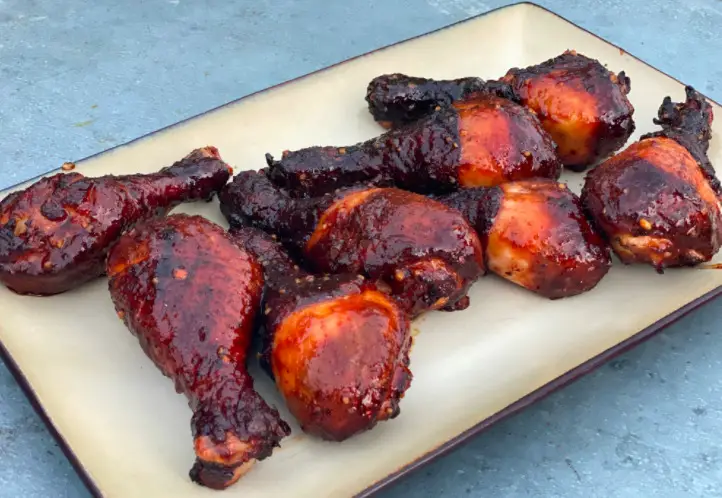 A plate of chicken and ribs on top of a table.