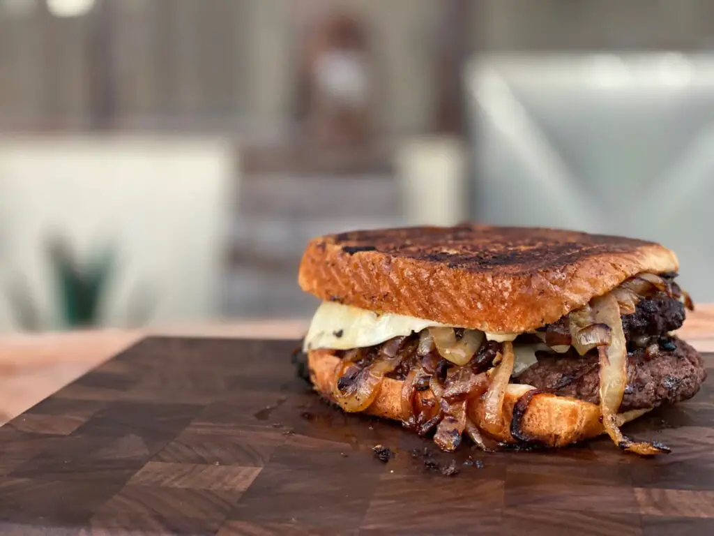 A sandwich sitting on top of a wooden cutting board.