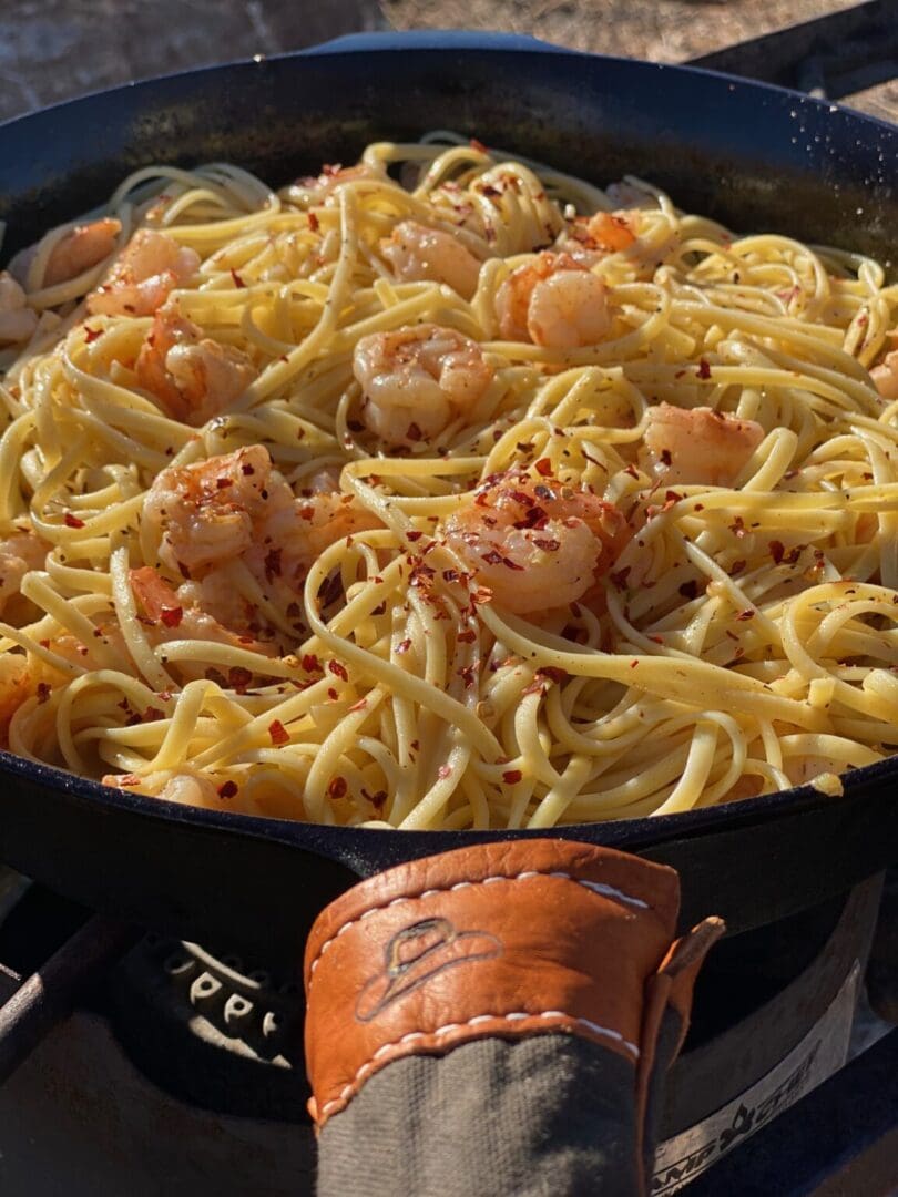 A pan of pasta with shrimp and cheese.