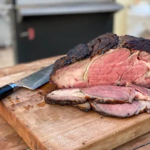 A large piece of meat on top of a cutting board.