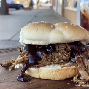 A sandwich with pulled pork and barbecue sauce.