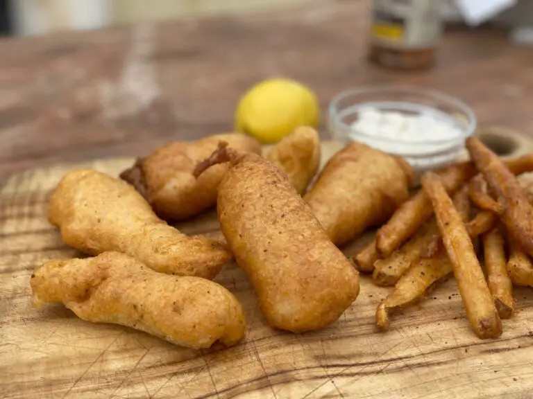 A wooden table topped with fish and fries.