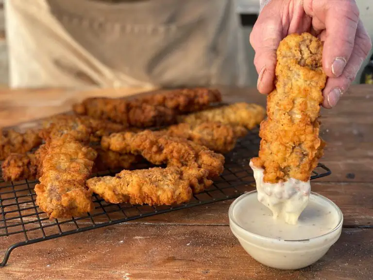 A person dipping some food into a bowl