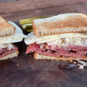 A sandwich cut in half on top of a wooden table.