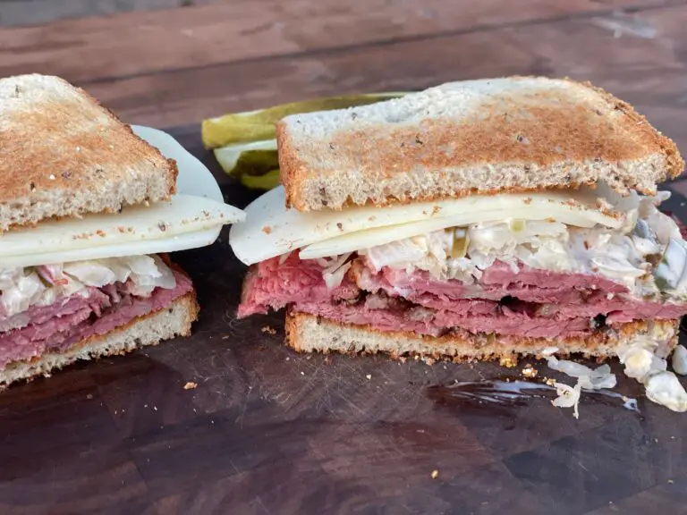 A sandwich cut in half on top of a wooden table.