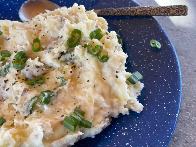 A plate of mashed potatoes with green onions.