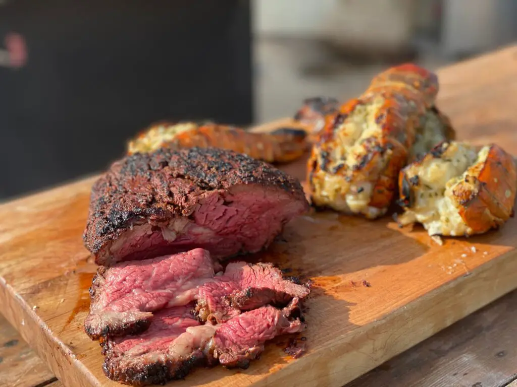 A steak and some other food on a cutting board.