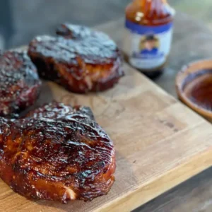 A wooden cutting board with some meat on it