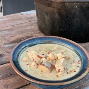 A bowl of soup on top of a wooden table.