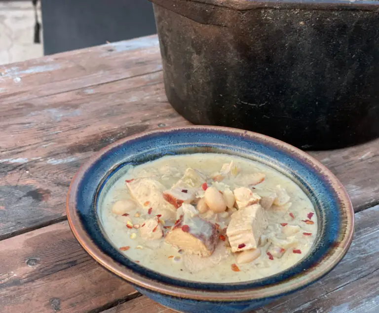 A bowl of soup on top of a wooden table.