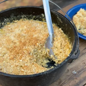 A bowl of macaroni and cheese with a spoon in it.