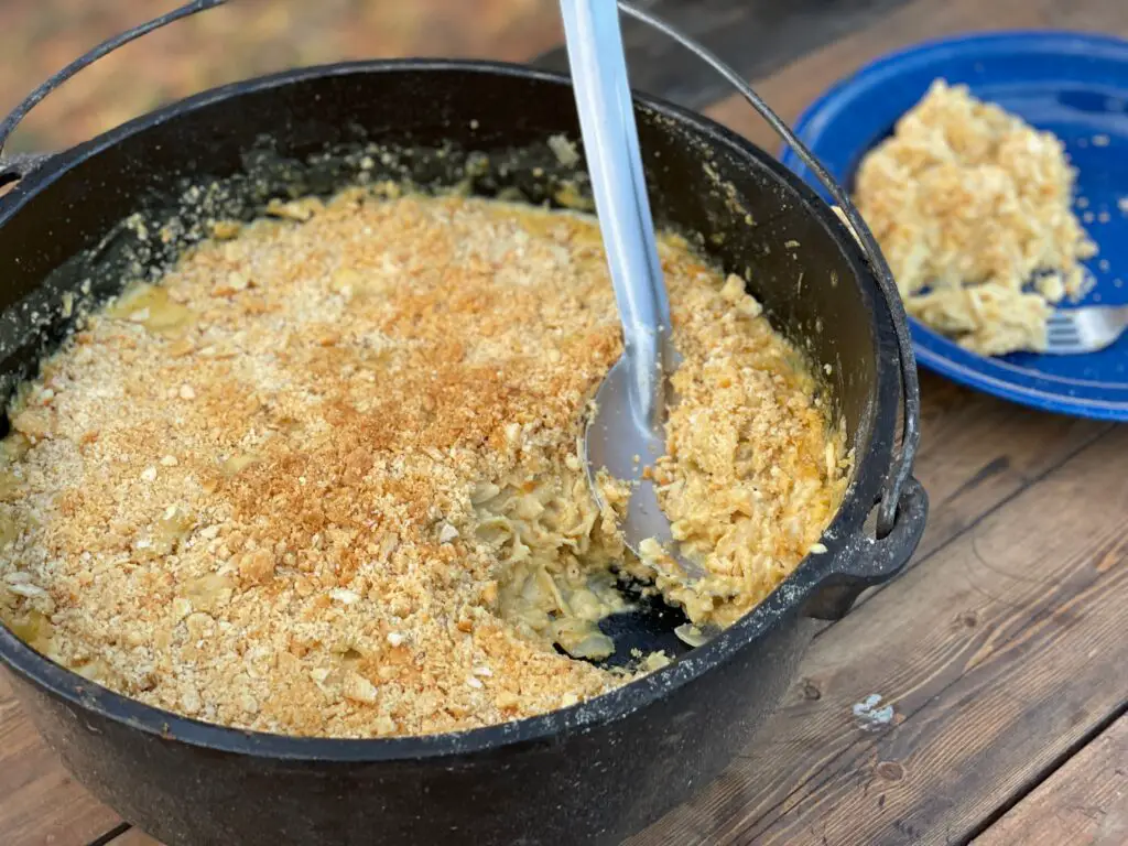 A bowl of macaroni and cheese with a spoon in it.