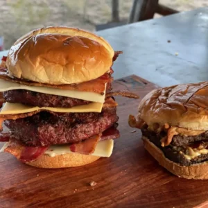 A large sandwich and a small burger on a table.