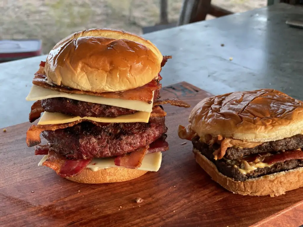 A large sandwich and a small burger on a table.