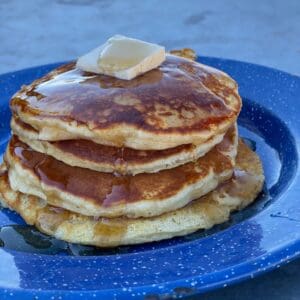 A stack of pancakes on top of a blue plate.