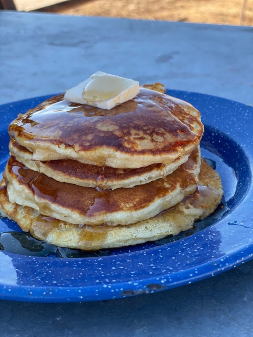 A stack of pancakes on top of a blue plate.