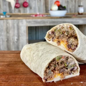 A burrito with meat and cheese on top of it.