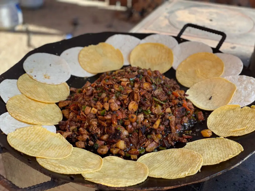 A pan of food with tortilla chips on the side.