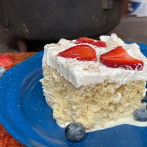 A piece of cake with strawberries on top.