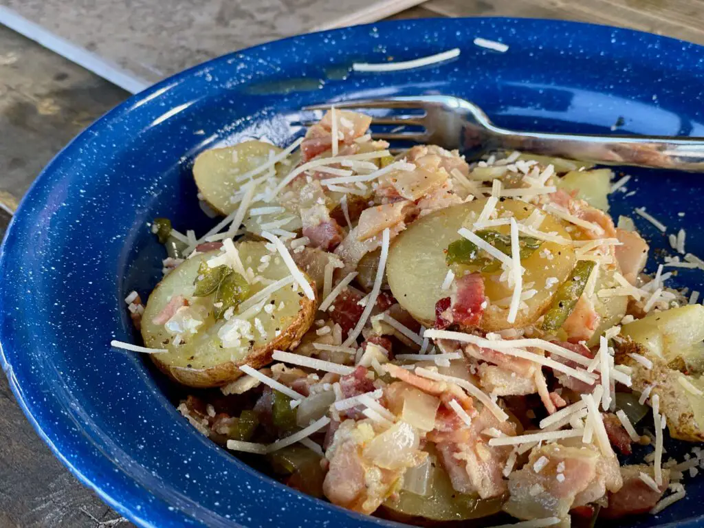 A blue bowl of food with cheese and tomatoes.