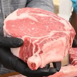 A person holding a piece of meat in their hands.