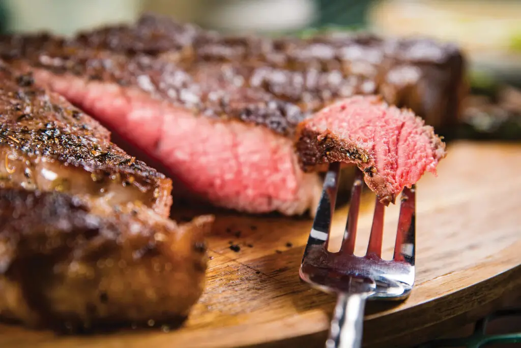 A close up of a fork and some meat