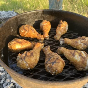 A grill with chicken cooking on it.