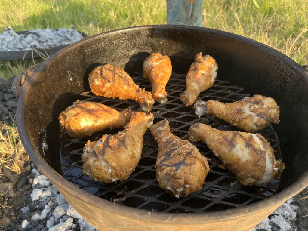 A grill with chicken cooking on it.