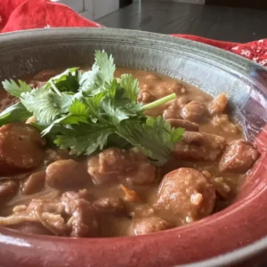 Bowl of red beans and sausage with cilantro.