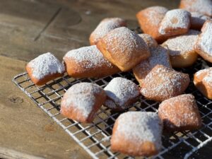 Beautiful beignets fried to a crispy golden brown and sprinkled lightly with powdered sugar.