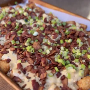 Tater tots with bacon, cheese, and green onions.