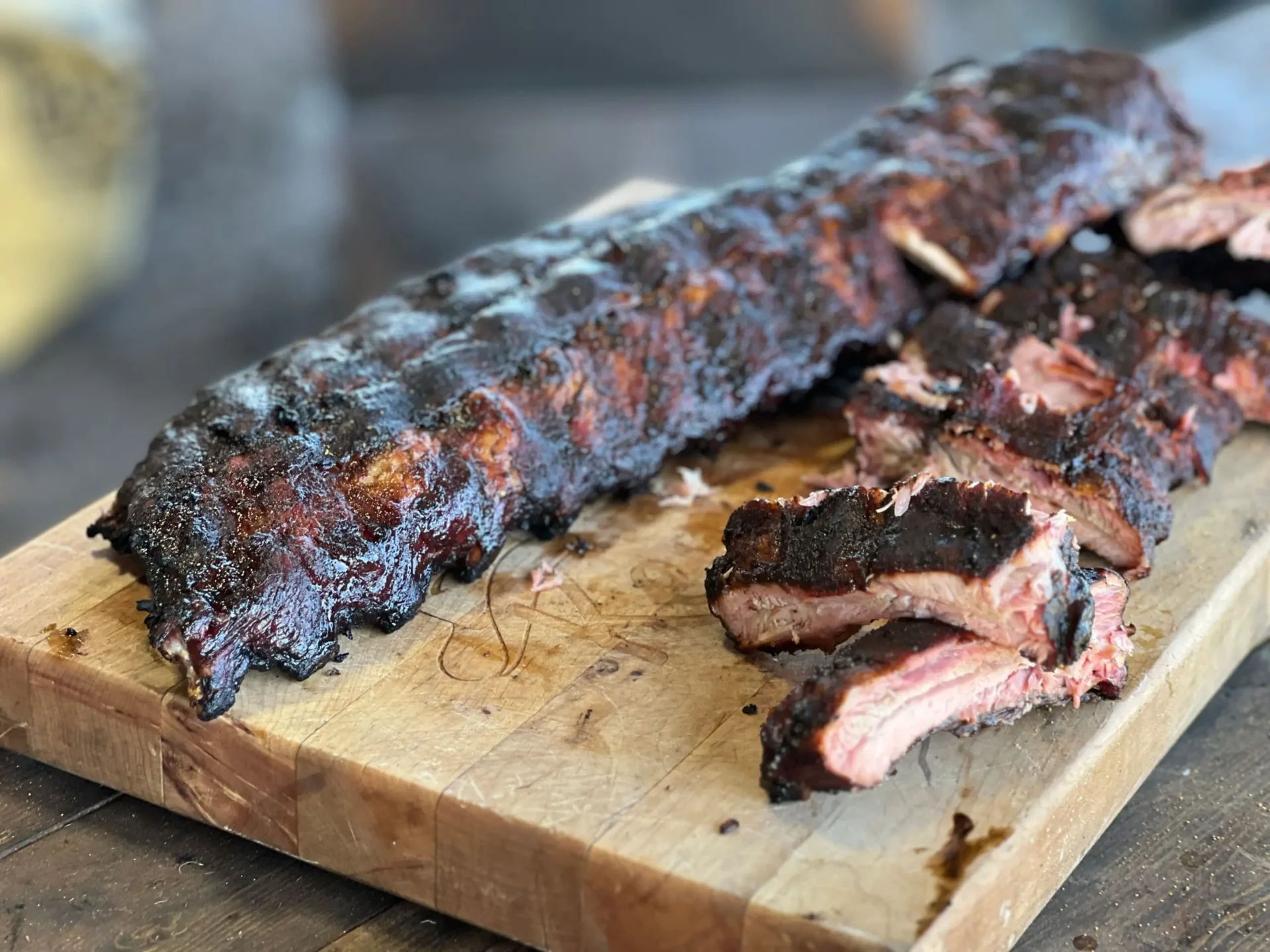 A slab of meat on top of a wooden cutting board.