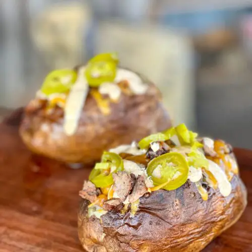 Two baked potatoes with extra crispy skin.