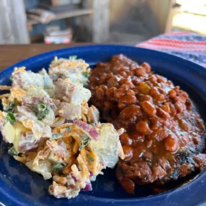 A plate of food with beans and potato salad.