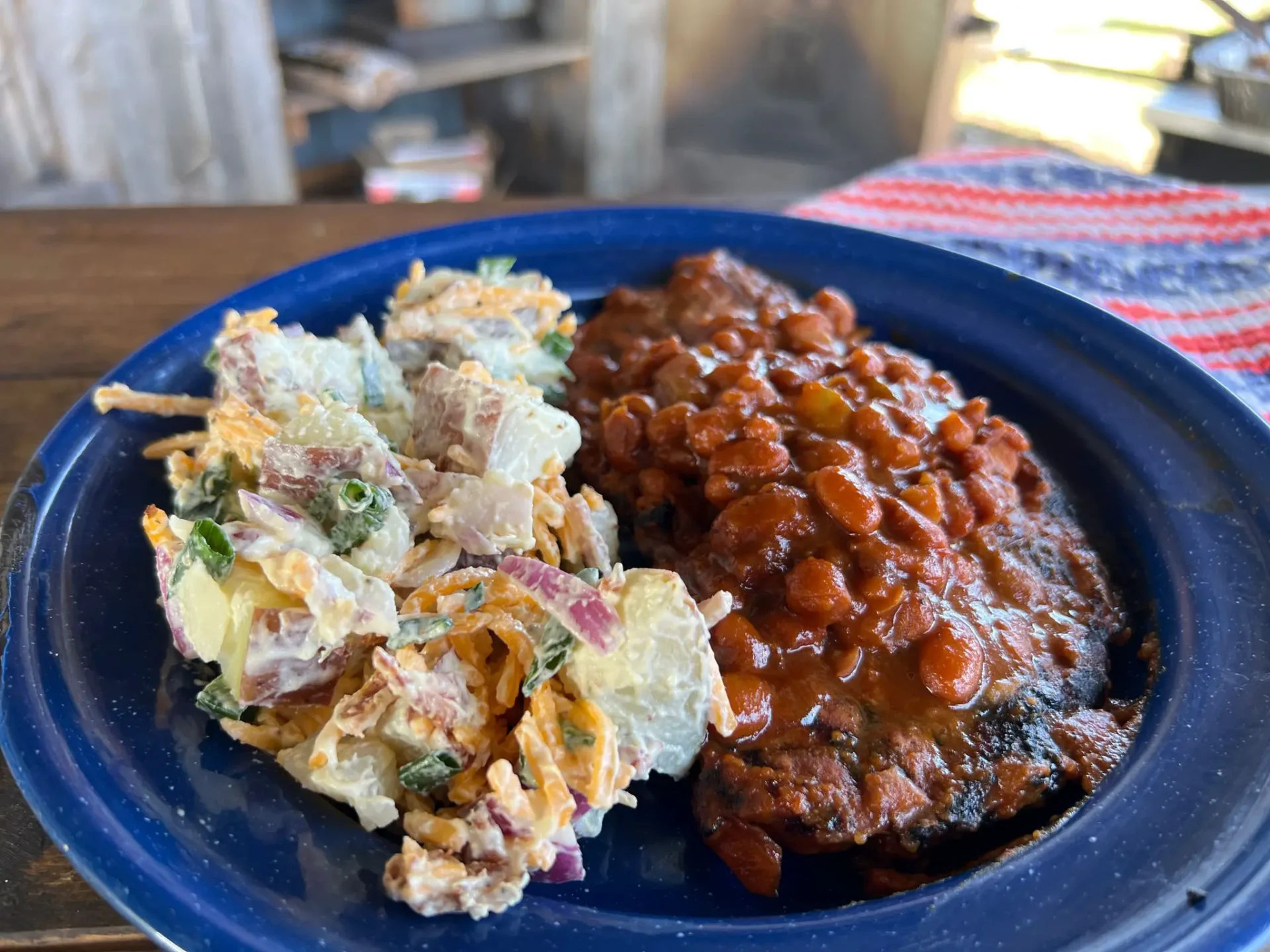 A plate of food with beans and potato salad.