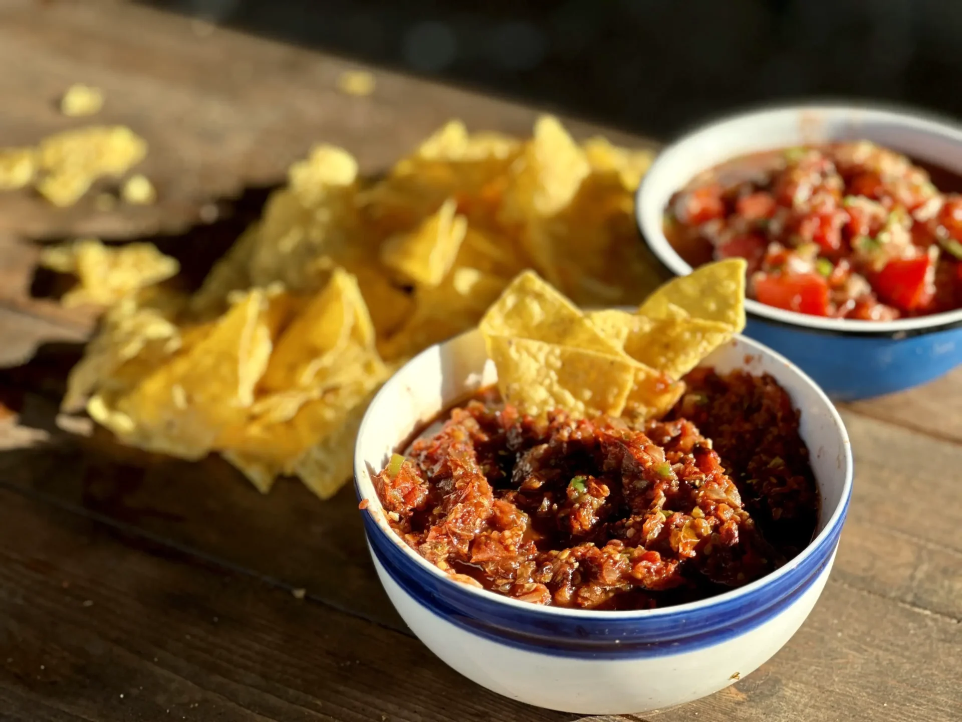 A bowl of chili next to some tortilla chips.