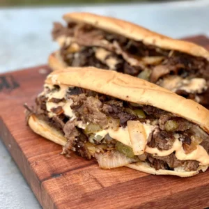 A close up of two sandwiches on a wooden board