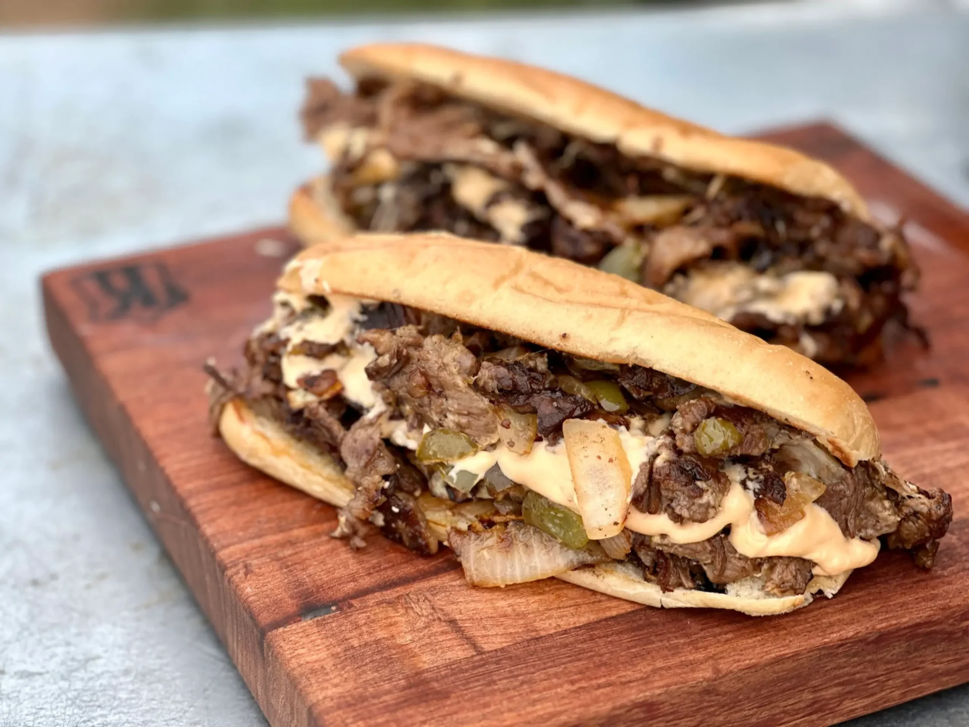 A close up of two sandwiches on a wooden board