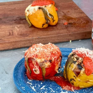 A blue plate with two stuffed peppers on it