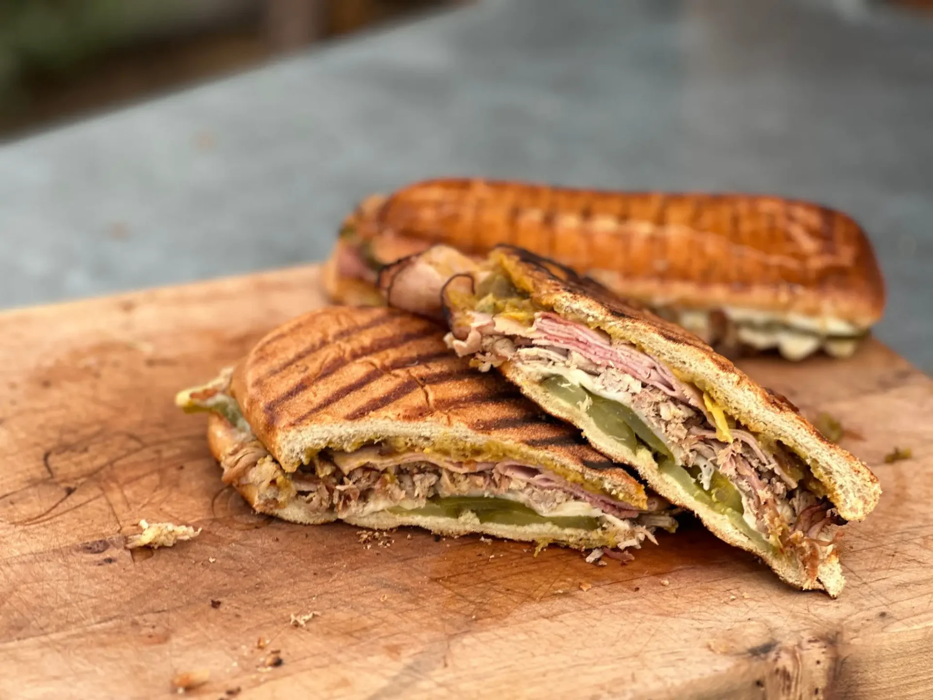 A cut in half sandwich sitting on top of a wooden cutting board.