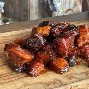 Smoked pork belly cubes on a cutting board.